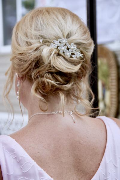 woman-wears-pink-for-her-wedding-reception-with-hair-done-up-in-curls-and-a-silver-heeled-hair-clip-t20-gl7qey.jpg
