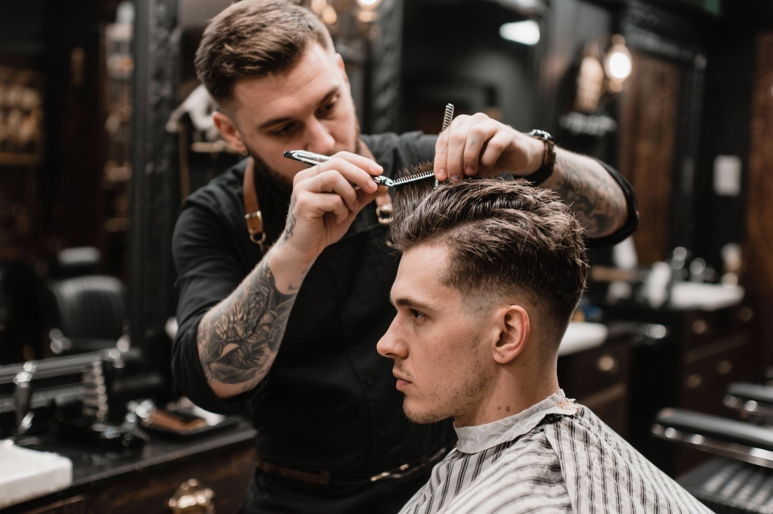 Barbier professionnel réalisant une coupe quiff moderne avec outils de précision dans un salon masculin